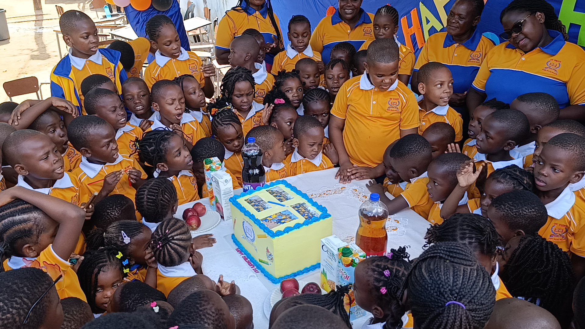 Learners gathered around the cake on Children's Day